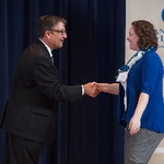 Doctor Smart shaking hands with an award recipient in a blue cardigan